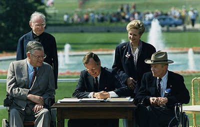 Photo of President George H. W. Bush signing the Americans with Disabilities Act