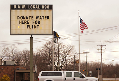 A sign says “Donate water here for Flint”